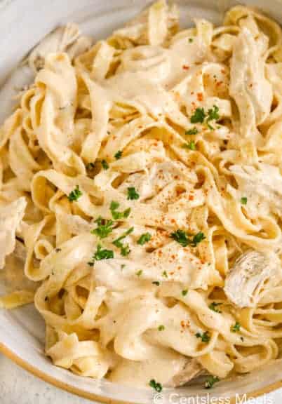 Cajun chicken alfredo in a bowl garnished with parsley