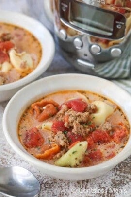Creamy tomato tortellini soup in white bowls garnished with parsley