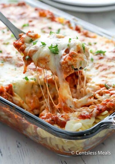 Sour cream noodle bake in a casserole dish with a scoop being taken out with a serving spoon