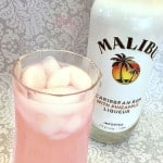 Bottle of Malibu liqueur next to a glass of sassy lemonade