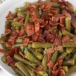 Texas Roadhouse green beans in a white bowl with bacon