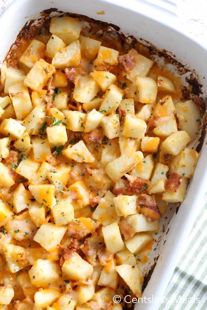 Cheesy ranch potatoes with bacon in a white casserole dish garnished with parsley