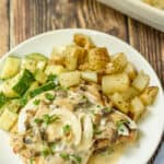 a plate of Pork Chops with Mushroom Gravy with potatoes and zucchini
