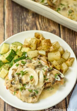 a plate of Pork Chops with Mushroom Gravy with potatoes and zucchini