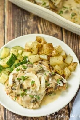a plate of Pork Chops with Mushroom Gravy with potatoes and zucchini