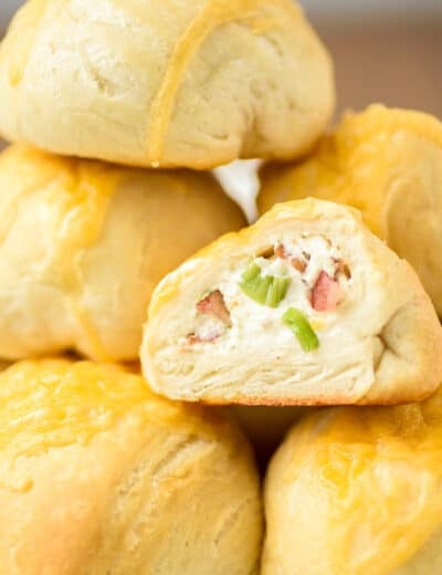 Bacon cream cheese bombs in a pile with one cut in half
