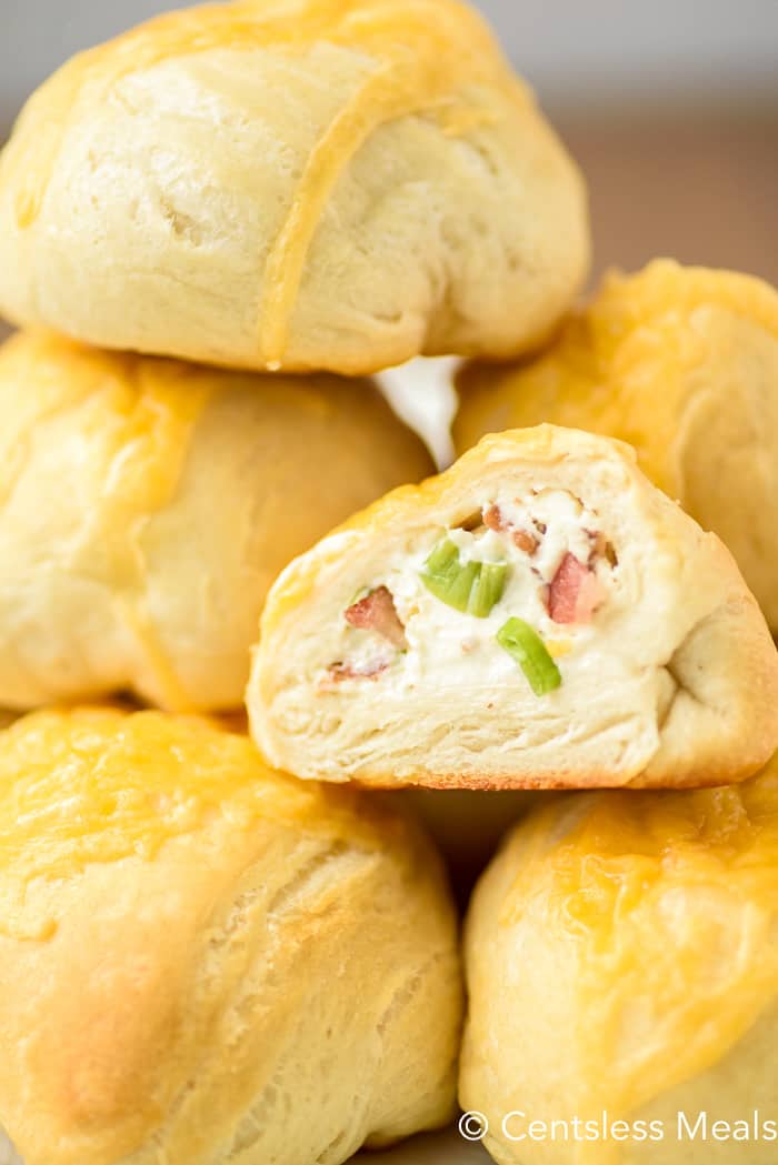 Bacon cream cheese bombs in a pile with one cut in half