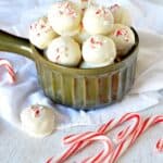 White chocolate peppermint truffles in a dish with candy canes on the side