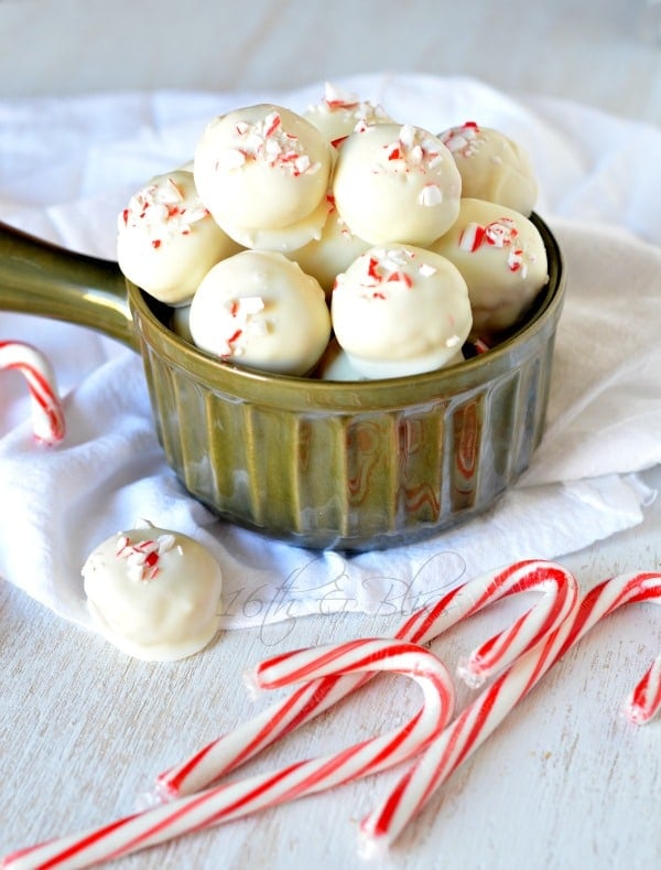 White chocolate peppermint truffles in a dish with candy canes on the side