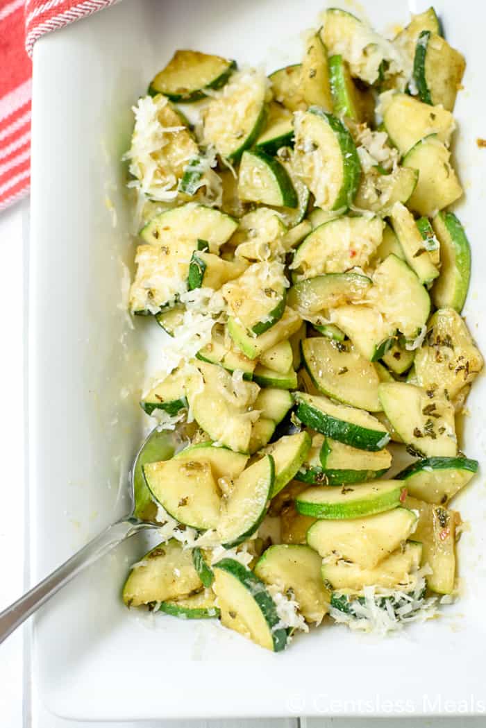 Parmesan zucchini in a white serving bowl with a spoon