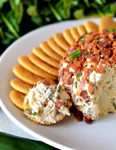 Bacon jalapeno cheese ball on a plate with crackers