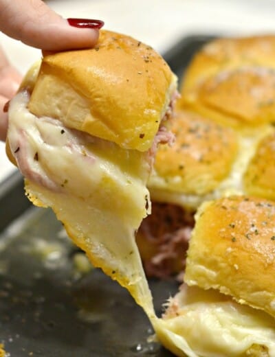 cheesy smithfield sliders with one being pulled out to show the melted cheese