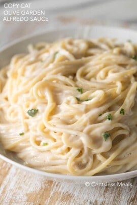 Copycat Olive Garden alfredo sauce with noodles and parsley in a bowl