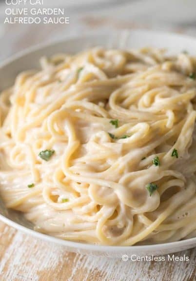 Copycat Olive Garden alfredo sauce with noodles and parsley in a bowl