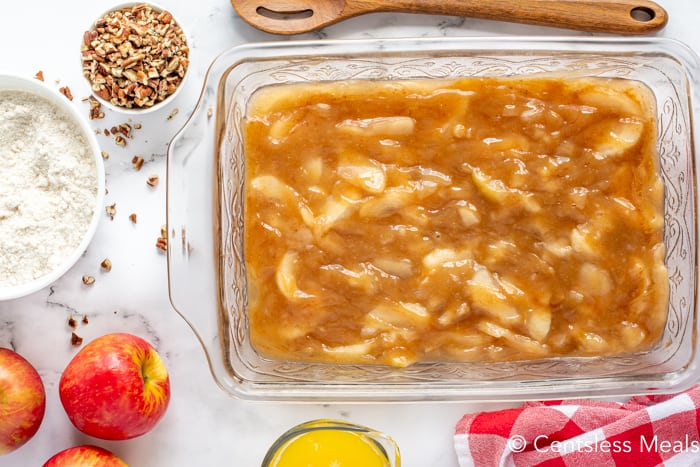 Caramel apple dump cake layer in a casserole dish