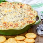 Hissy Fit Dip in a green casserole dish with crackers on the side