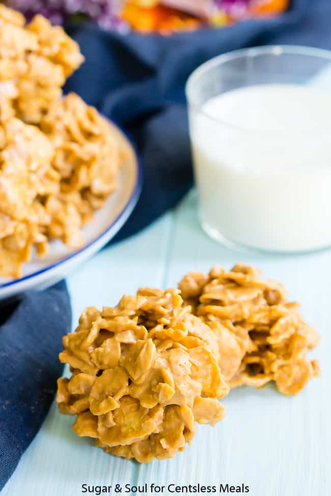Butterscotch Crunchies on a wooden board with a glass of milk and plate of butterscotch Crunchies in the background