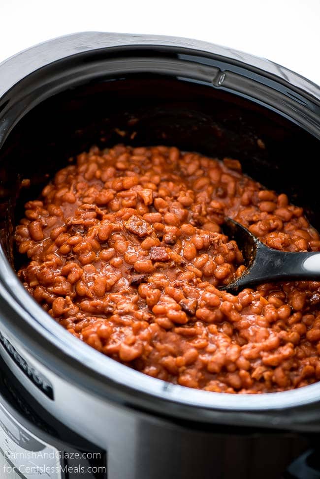 Crock-Pot baked beans in a Crock-Pot with a spoon