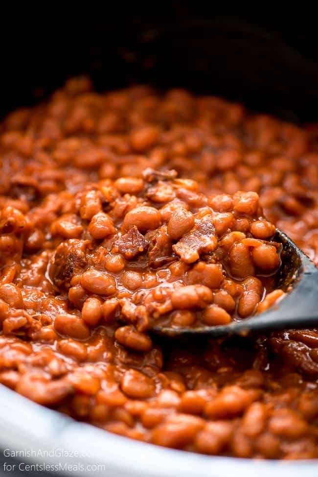 Crock-Pot baked beans being scooped up with a spoon