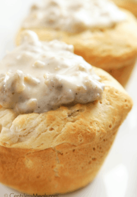 Biscuits and gravy cups on a white plate with gravy on top