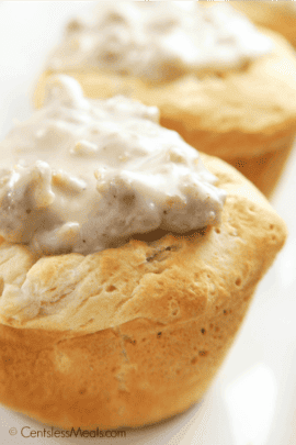 Biscuits and gravy cups on a white plate with gravy on top