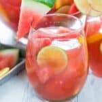 Watermelon sangria in a glass garnished with watermelon lime and lemon slices