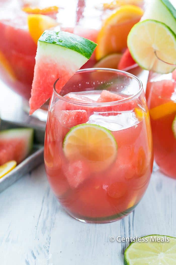 Watermelon sangria in a glass garnished with watermelon lime and lemon slices