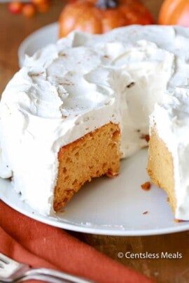 Pumpkin angel food cake on a white plate with a piece taken out