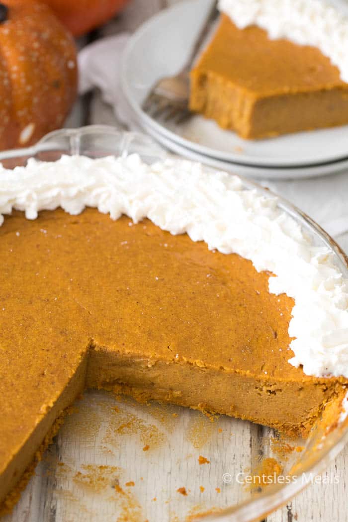 Crustless pumpkin pie in a pie plate and on a plate in the background