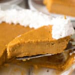 Piece of pumpkin pie on a pie server being served from the pie plate