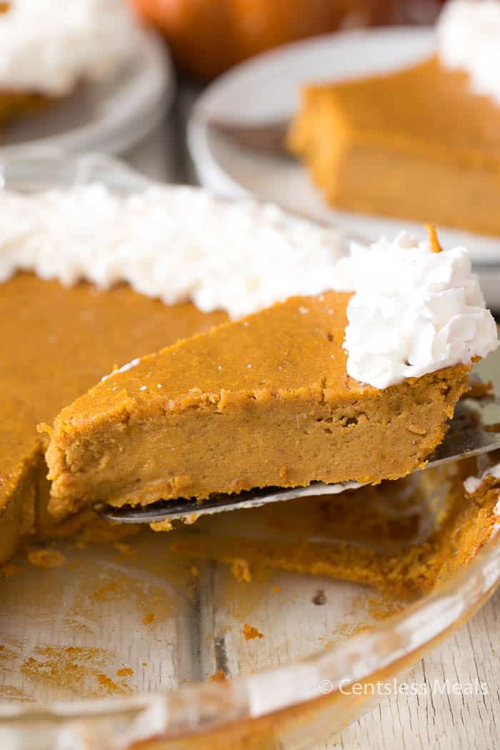 Piece of pumpkin pie on a pie server being served from the pie plate