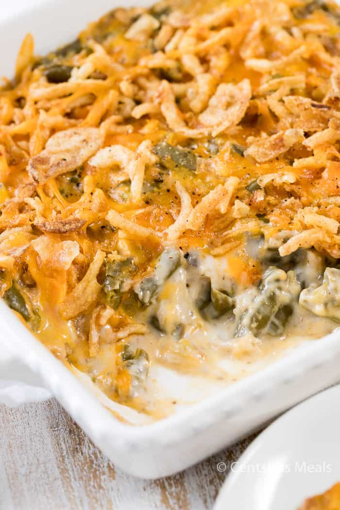 Green bean casserole in a white casserole dish with a spoonful taken out