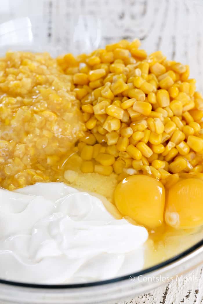 Ingredients for creamed corn casserole in a glass bowl