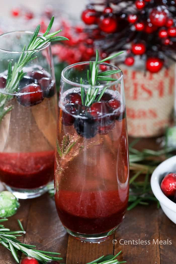 Cranberry mimosas with cranberry and rosemary in them