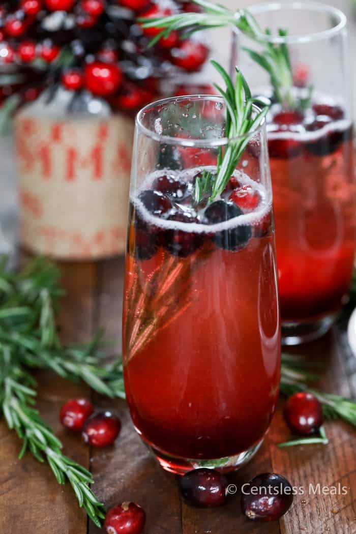 Fresh cranberry mimosas with cranberries and rosemary as garnish