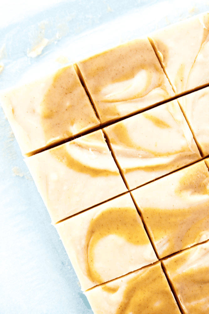 White chocolate peanut butter swirl fudge cut into squares on parchment paper