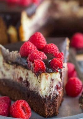 Brownie Bottom Raspberry Cheesecake is a sinful combination of chocolate and creamy raspberry cheesecake topped with chocolate ganache.