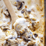 Overhead shot of Chicken and Mushroom Casserole in baking dish with a wooden spoon