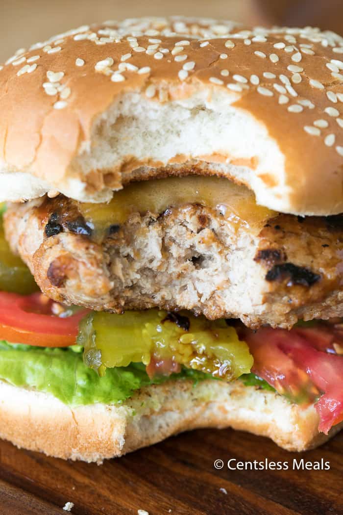 Turkey burger on a wooden board with a bite taken out