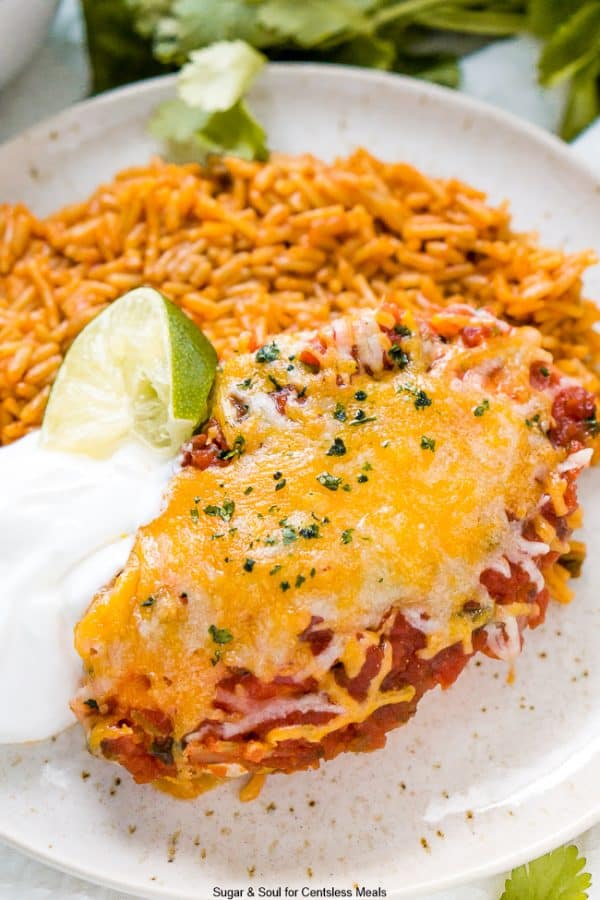 Salsa Chicken Bake on a white plate with rice and side of sour cream