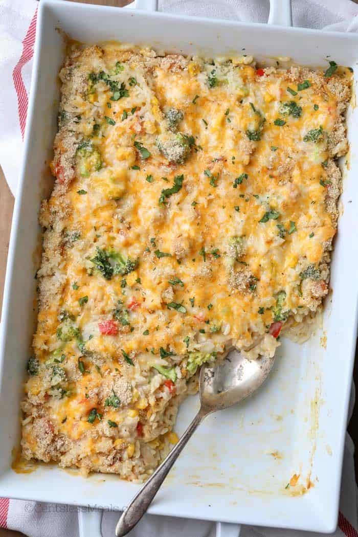 Chicken broccoli rice casserole in a casserole dish with a scoop taken out