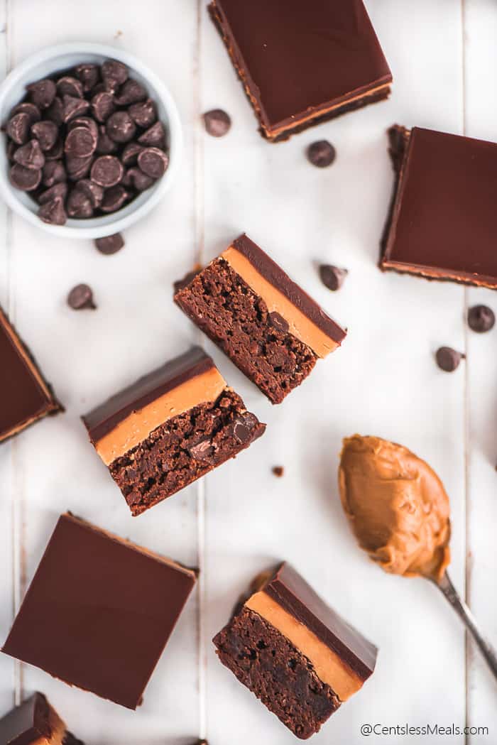 Buckeye brownies on a wooden board with peanut butter and chocolate chips on the side