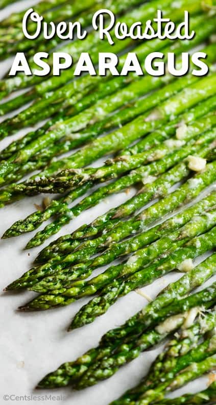 Oven Roasted Asparagus lined up on parchment paper with writing.