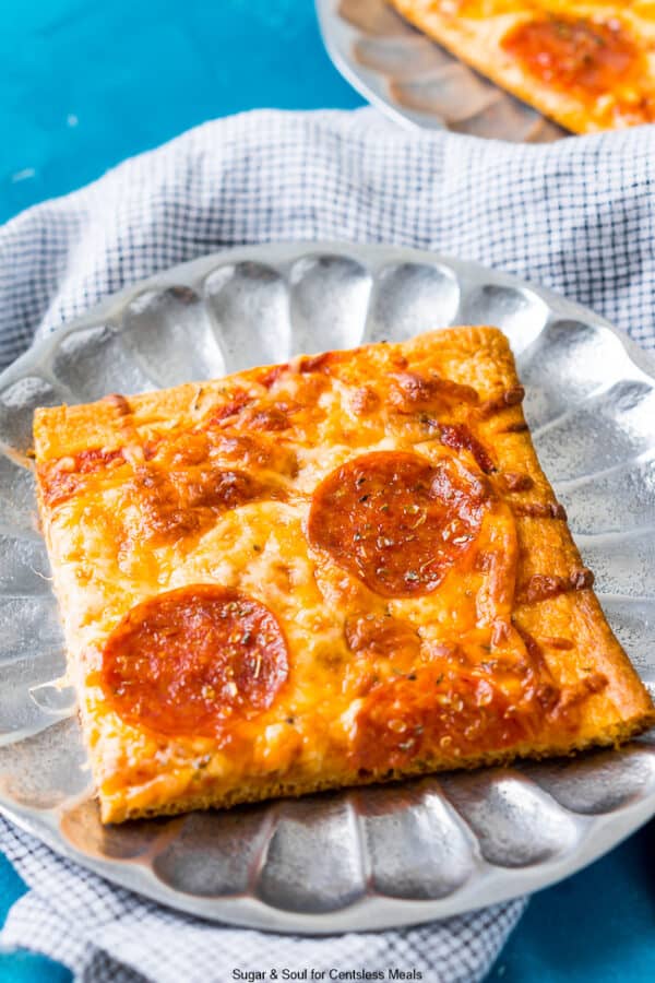 Piece of crescent roll pizza on a metal plate