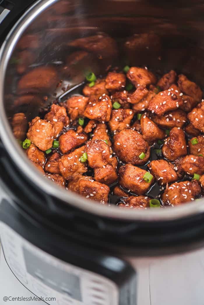 Instant pot honey garlic chicken in an instant pot with sesame seeds and green onions