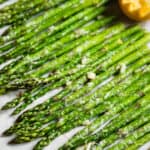 roasted asparagus lined up on parchment paper