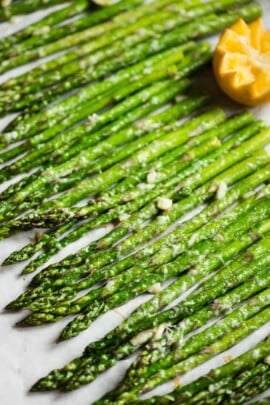 roasted asparagus lined up on parchment paper