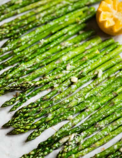 roasted asparagus lined up on parchment paper