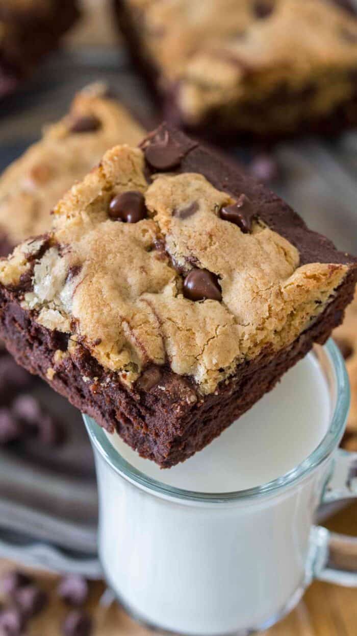 A brookie sitting on a glass of white milk