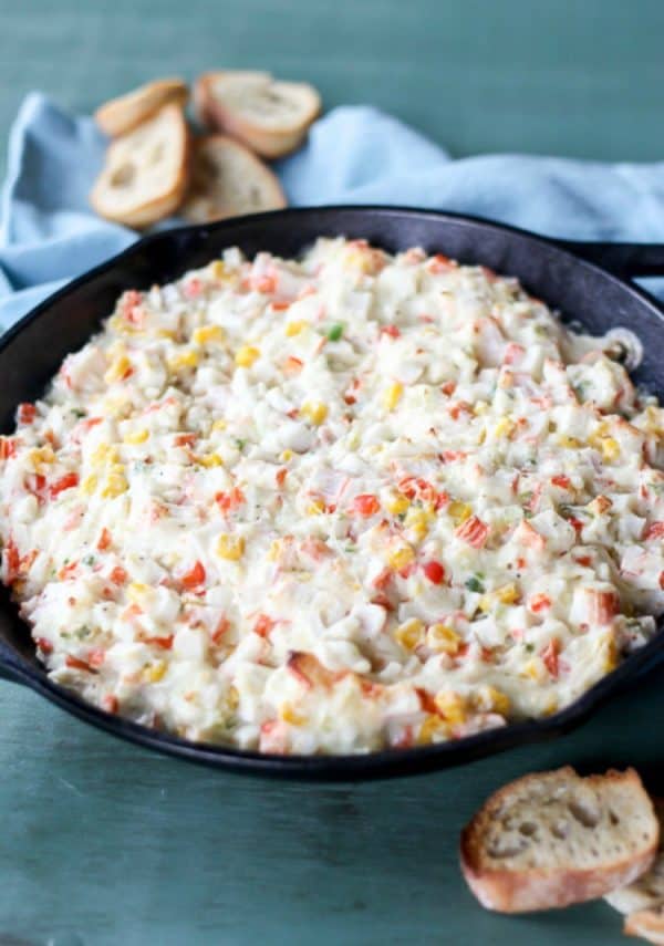 Hot crab dip in a bowl with pieces of bread on the side